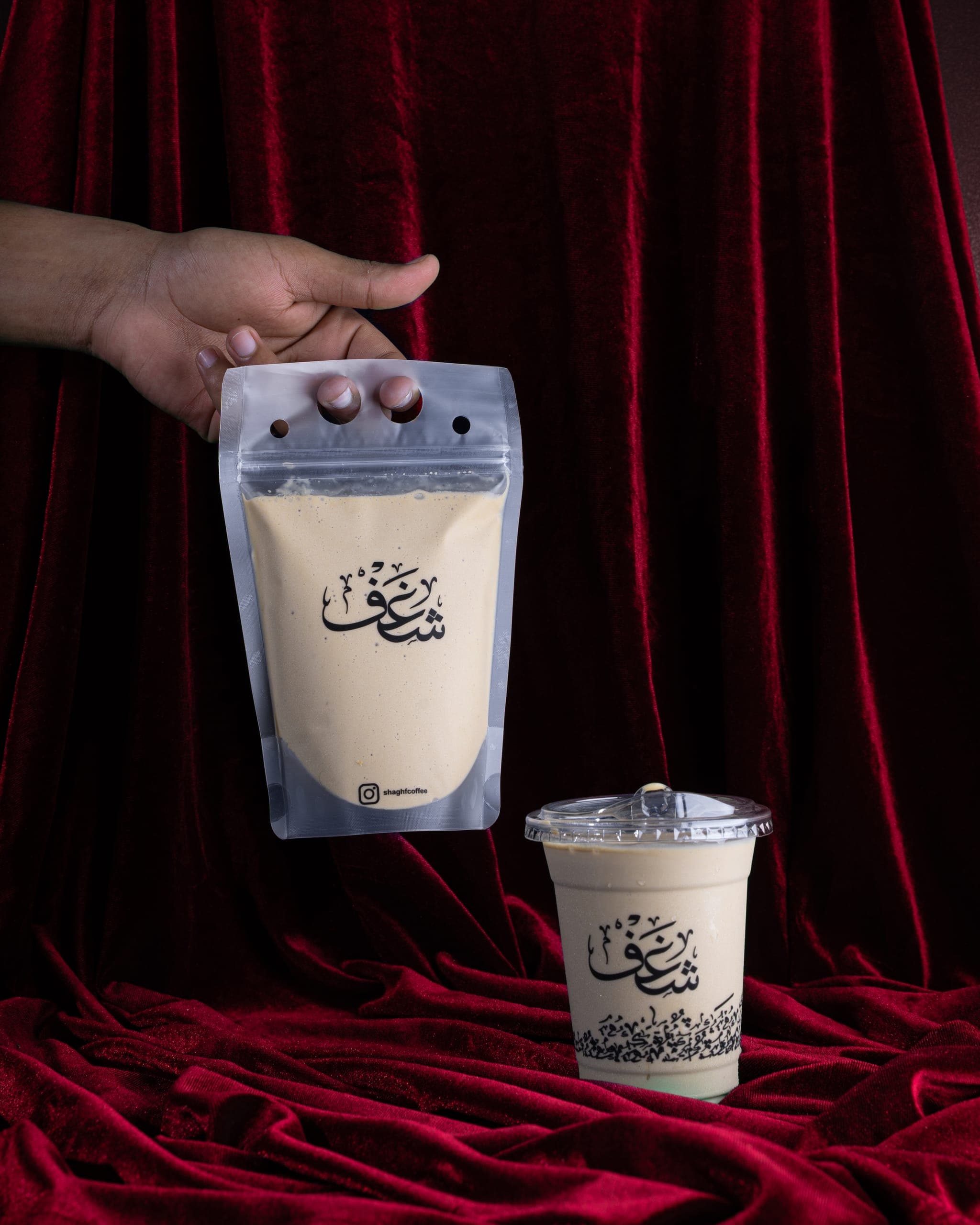 A Shaghf drink pouch and cup, printed with the name in Arabic, on red velvet