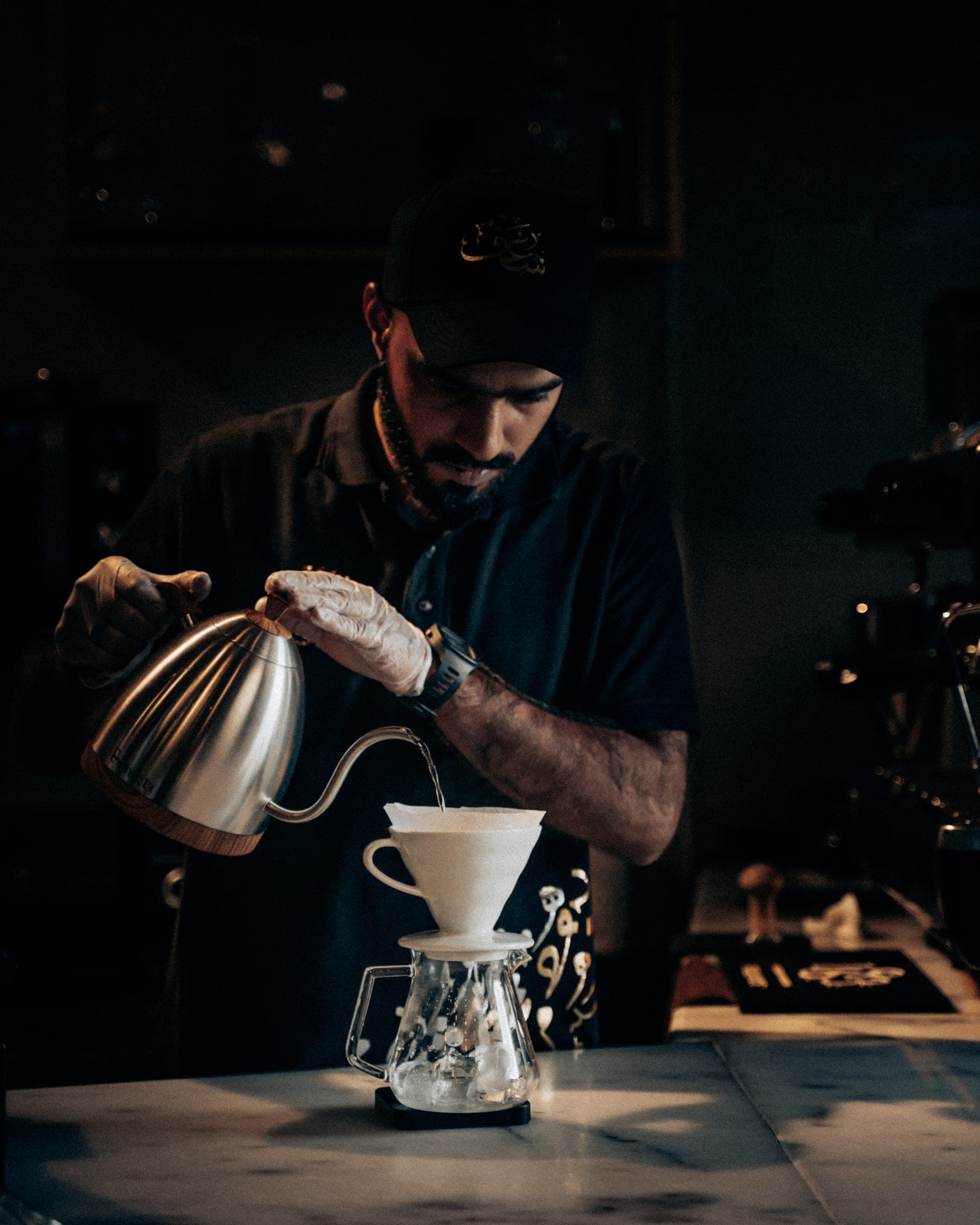 A Shaghf barista slowly pouring water over a V60 coffee dripper